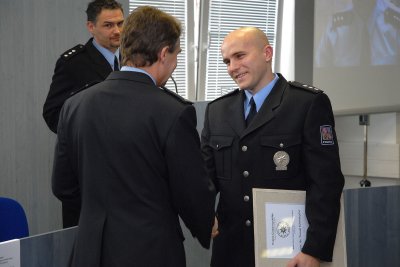 Nadporučík Tomáš Dohnal přebírá z rukou okresního policejního ředitele ocenění Manažer roku. Výslednost kopřivnického obvodu, který vede, hodnotí vedení okresu vysoko.<br /> 
FOTO: D. MACHÁČEK
