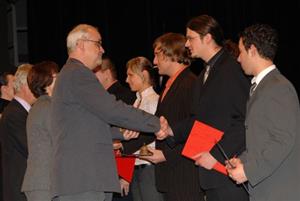 Čerství absolventi vyšší odborné školy přebírají drobný dárek a gratulace k absolutoriu od místostarosty Zdeňka Krajčíra.<br/>                   
FOTO: DAVID MACHÁČEK

