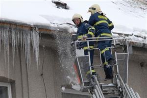 Tatrováčtí hasiči při likvidaci nebezpečných rampouchů visících ze střechy ZŠ Milady Horákové. Podobných výjezdů absolvovali v poslední době celou řadu. <br/>                 
FOTO: DAVID MACHÁČEK
