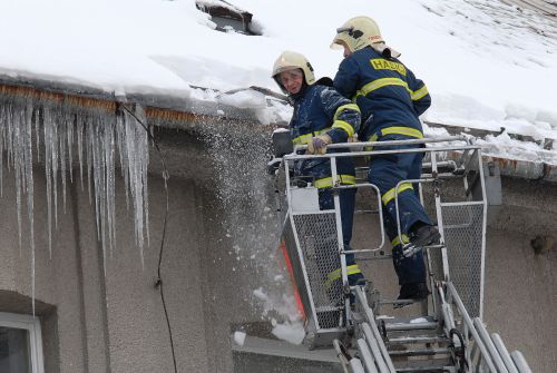 Tatrováčtí hasiči při likvidaci nebezpečných rampouchů visících ze střechy ZŠ Milady Horákové. Podobných výjezdů absolvovali v poslední době celou řadu. <br/>                 
FOTO: DAVID MACHÁČEK
