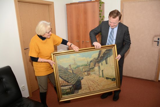 Eva Šimáčková předává starostovi Kopřivnice Josefu Jalůvkovi obraz, který zhruba před pětasedmdesáti lety namaloval její otec.
FOTO: DAVID MACHÁČEK