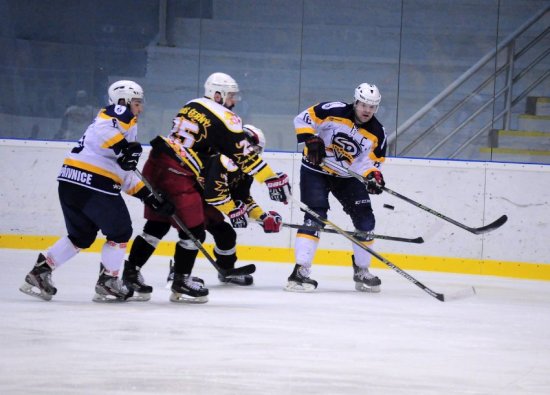 Martin Tomášek (s kapitánským céčkem) posílá puk z dosahu dvou opavských hráčů, na které dotírá další kopřivnický hráč David Čintala (vlevo).
FOTO: KRISTINA ČABLOVÁ