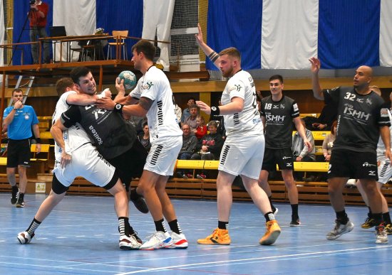 Házenkáři Kopřivnice (tmavší dresy) v 15. kole extraligy v tomto utkání doma rozstříleli Strakonice. Na snímku se probíjí obranou soupeře Radek Doležel.
FOTO: MAREK HAVRAN