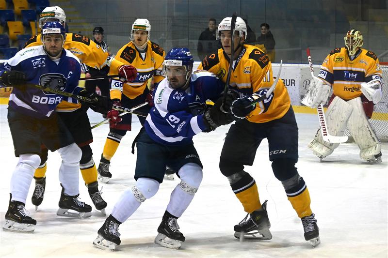 Hokejisté Kopřivnice v tomto duelu s Bobry urvali dva body za výhru v prodloužení, na snímku zprava domácí brankář Mokrý, Pindel, hostující Vávra a vzadu Hlaváč. FOTO: MAREK HAVRAN
