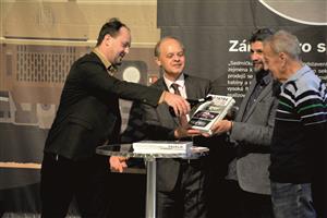 Ředitel Muzea Novojičínska křtí šampaňským knihu, kterou třímají v rukou autor Martin Kupec a ilustrátor Jan Hlavín. FOTO: DAVID MACHÁČEK