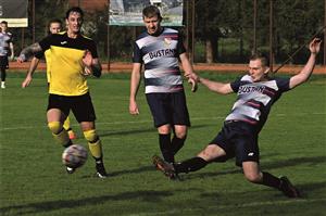 Fotbalisté Vlčovic-Mniší (světlejší dresy, s míčem útočník Michal Motúz) v domácím utkání 17. kola s Fryčovicemi doháněli ztrátu a nakonec urvali bod. FOTO: MAREK HAVRAN