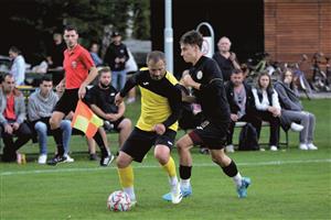Fotbalisté Vlčovic-Mniší (ve světlejším dresu Roman Vrba) po dvoutýdenní pauze předvedli dobrý výkon a favorizovaný Příbor pořádně potrápili. FOTO: DAVID MACHÁČEK