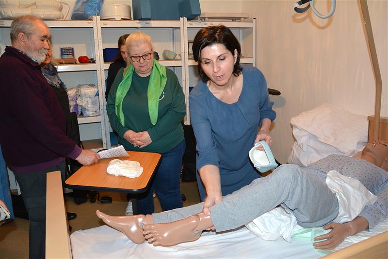 Simona Hanzelková ze SSSmK ukazovala členům Svépomocné skupiny kompenzační pomůcky, které jim mohou usnadnit péči o jejich blízké